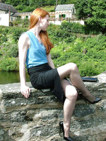 Cute redhead Miranda flashing her shiny stilettos and stockings by the lake