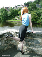 Cute redhead Miranda flashing her shiny stilettos and stockings by the lake