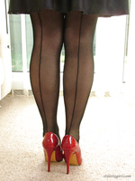 Alison is dressed to impress in her shiny black dress and red stilettos