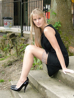 Blonde outdoors in lacy stockings and patent heels