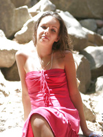 Sexy teen sits out on some rocks in the shadows in her pink prom like dress so sexy