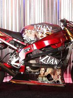 Blonde sweetheart, Rachel Aziani, looks amazing posing with the stunt bike in her tank top that shows off her big boobs and thigh-high black boots!