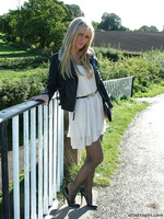 Gorgeous blonde Erin is outdoors showing off her shiny legs covered in silky nylon and her beautiful black stilettos