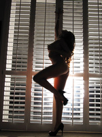 Sexy Katsuni strikes a pose in front of the shutters before striking a pose on her knees